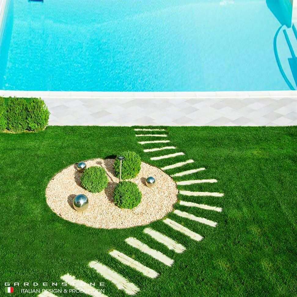 Camminamento irregolare di piastre in finta pietra distanziate che conducono alla piscina